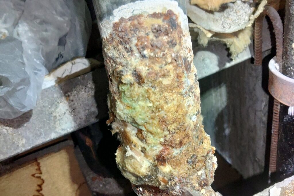 An old galvanized water pipe crusted with corrosion, found on a Tulsa Plumbing & Remodeling job.