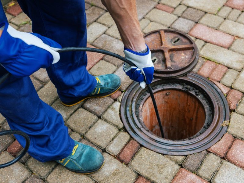 sewer cleaning service – worker clean a clogged drainage with hydro jetting sewer cleaning service - worker clean a clogged drainage with hydro jetting